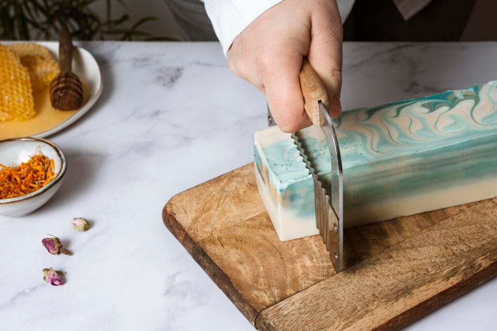 man cutting soap on wooden board