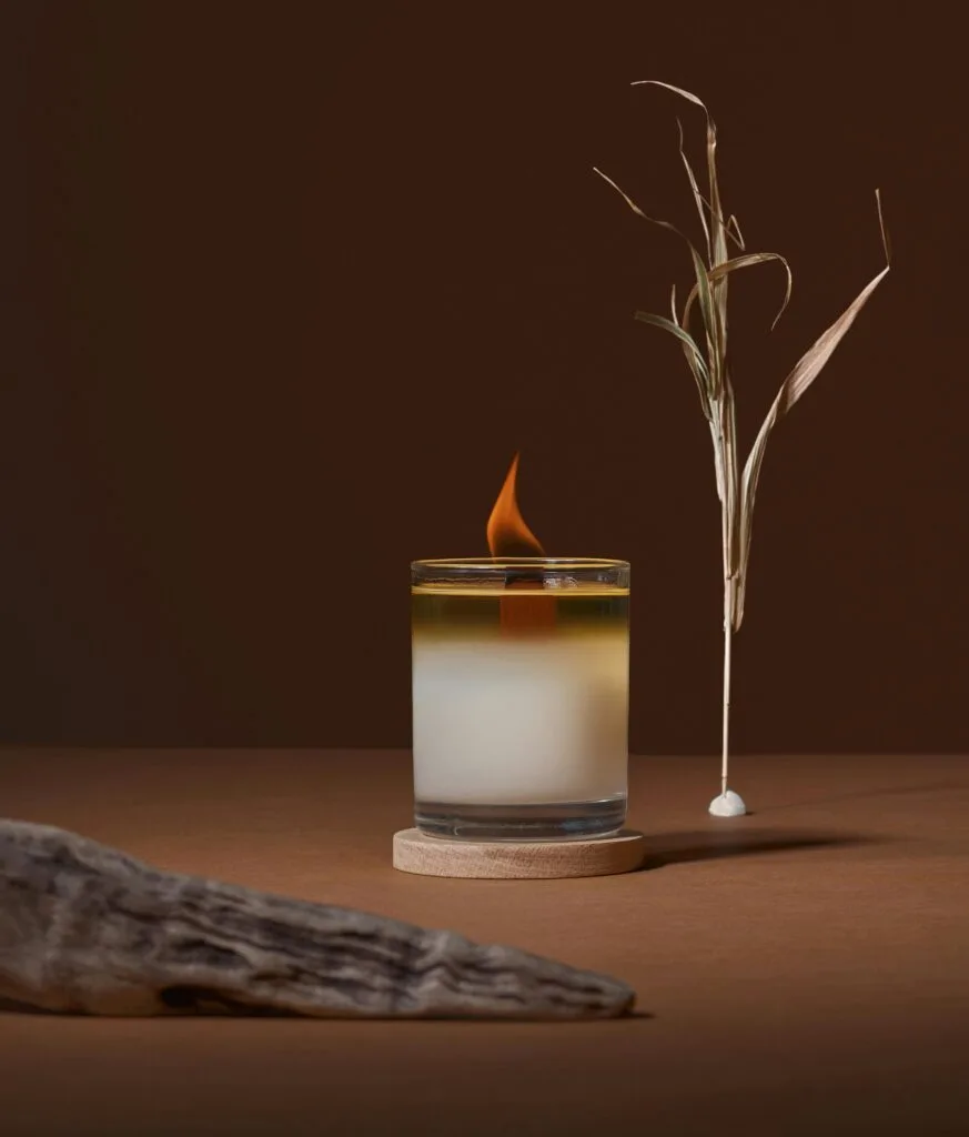 wooden wick candle leaf in background